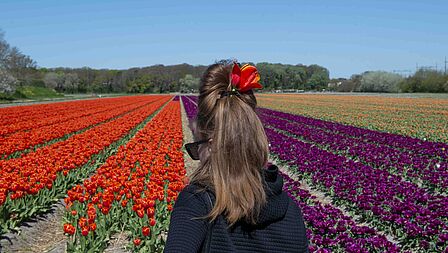 vrouw kijkt naar bloembollenveld