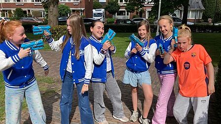 De meiden van de kindergemeenteraad op het Raadhuisplein met hun lasergame attributen